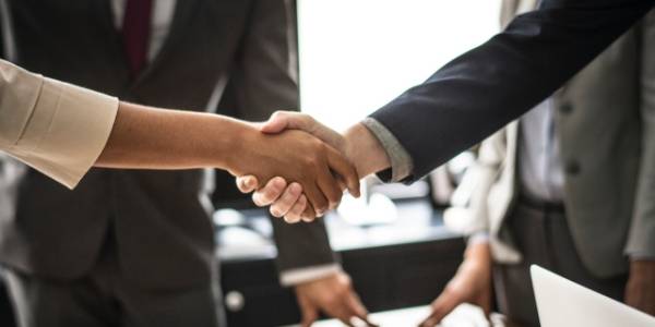 2 businessmen are shaking hands together.